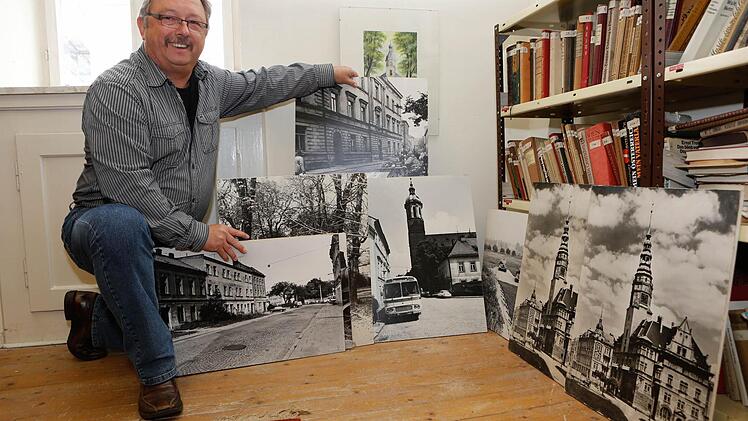 Dieter Rehmann zeigt alte Fotografien von Troppau vor dem Krieg, die im Troppau-Zimmer aufbewaht werden.