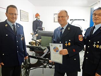 Hartmut Ehrsam (Mitte) wurde zum Ehrenmitglied ernannt. Kommandant Thomas Schelhorn (links) und Vorsitzender Gerhard Moser (rechts) wiesen auf das anstehende Jubiläum hin.  Foto: Doris Weidner