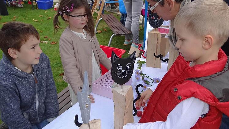 Enya (Zweite von links) hatte nicht nur allerhand mit dem Bemalen der Kätzchenköpfe zu tun, sondern auch mit dem Verkauf am bunten Herbstmarkt. Aber sie konnte die vielen Eltern und Großeltern von ihrer Ware überzeugen. Ihr ehemaliger Kindergartenfreund Benedikt (Erster von links) half ihr dabei.