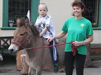 Maja Joel führt den Maulesel mit Sohn Leon im Hof umher, Muli Nummer zwei läuft frei herum. Die beiden Tiere sollen künftig für Touren auf dem Mühlenweg und auf den Wanderwegen rund um die Neumühle verliehen werden. Foto: Sonja Adam