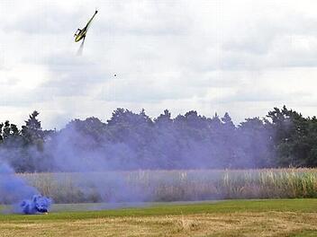 Flink lässt Erik Fischer aus Rothwind den Modellhubschrauber um die lila Rauchwolke tänzeln, die vom Boden aufsteigt. Die Idee dazu hatte Daniel Götz aus Kulmbach. Foto: Stephan Stöckel