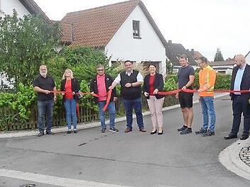 Mit dem symbolischen Durchschneiden eines Bandes haben Bürgermeisterin Angela Hofmann (Fünfte von links) und in Stellvertreter Michael Zwingmann (links daneben) im Beisein weiterer Gäste die Frankenstraße und den Mittelweg mit einem Teilstück der St.-Sebastians-Straße in Neuses für den Verkehr freigegeben.