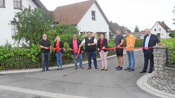 Mit dem symbolischen Durchschneiden eines Bandes haben Bürgermeisterin Angela Hofmann (Fünfte von links) und in Stellvertreter Michael Zwingmann (links daneben) im Beisein weiterer Gäste die Frankenstraße und den Mittelweg mit einem Teilstück der St.-Sebastians-Straße in Neuses für den Verkehr freigegeben.