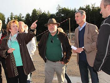 Im Brückenauer Gewerbegebiet auf dem Buchrasen: Bürgermeisterin Brigitte Meyerdierks (v. l.), Senior-Chef Josef Enders, 2. Bürgermeister Jürgen Pfister und Junior-Chef Marc Enders im Gespräch. Im Hintergrund ist die Höhe der geplanten Aufschüttung markiert. Foto: Ulrike Müller