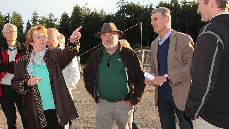 Im Brückenauer Gewerbegebiet auf dem Buchrasen: Bürgermeisterin Brigitte Meyerdierks (v. l.), Senior-Chef Josef Enders, 2. Bürgermeister Jürgen Pfister und Junior-Chef Marc Enders im Gespräch. Im Hintergrund ist die Höhe der geplanten Aufschüttung markiert. Foto: Ulrike Müller