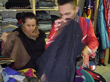 Helal Abdulghani hilft einer Kundin des Brückenauers Kramlädchens, passende Kleidung zu finden. Foto: Julia Raab
