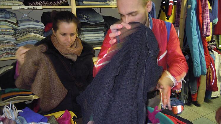 Helal Abdulghani hilft einer Kundin des Brückenauers Kramlädchens, passende Kleidung zu finden. Foto: Julia Raab