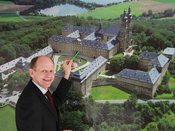 Michael Möslein vor einem Luftbild des Klosters: Hier werden die Dimensionen der historischen Anlage besonders deutlich. Foto: Matthias Einwag