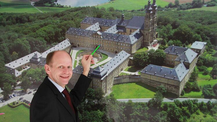Michael Möslein vor einem Luftbild des Klosters: Hier werden die Dimensionen der historischen Anlage besonders deutlich. Foto: Matthias Einwag