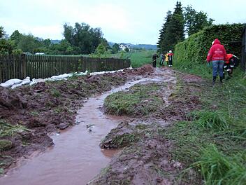 Wassermassen und Schlamm schossen in Fischbach an der "Alte Bundesstraße" ins Tal und drohten erneut das Anwesen von Anita Krause zu überfluten. Helfern der Feuerwehr und Nachbarn gelang es rechtzeitig, mit Schaufeln einen Wall zu bauen. Zudem wurden Sandsäcke zum Schutz verbaut. Foto: Michael Will