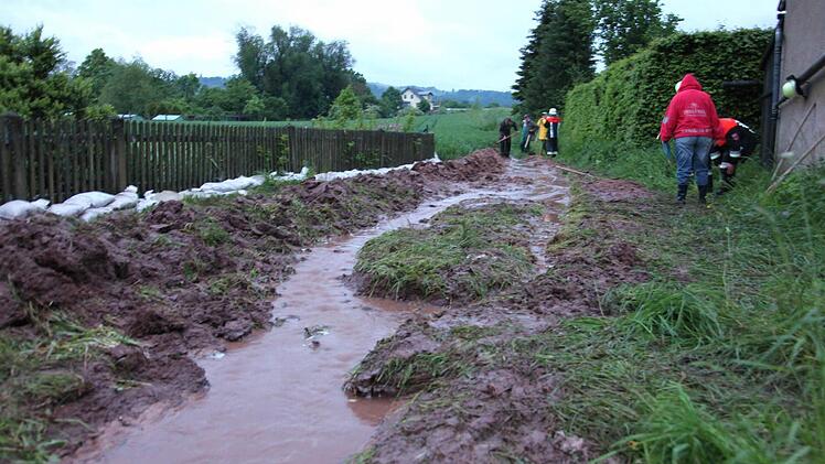 Wassermassen und Schlamm schossen in Fischbach an der "Alte Bundesstraße" ins Tal und drohten erneut das Anwesen von Anita Krause zu überfluten. Helfern der Feuerwehr und Nachbarn gelang es rechtzeitig, mit Schaufeln einen Wall zu bauen. Zudem wurden Sandsäcke zum Schutz verbaut. Foto: Michael Will