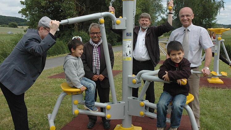 Nicht nur für Kinder ist der Familienaktivbereich gedacht Pfarrer Stefan Köttig (von links), Eckehard Tschapke, Pfarrer Richard Brütting und Bürgermeister Wilhelm Schneider zeigten an einem Outdoorgerät, welche Möglichkeiten zur Körperertüchtigung möglich sind. Foto: Schmidt