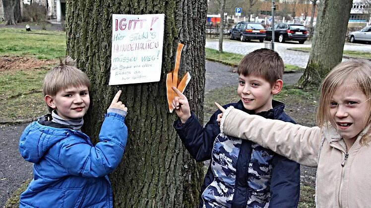 Rostik, Leon und Vanessa (von links) zeigen auf ein Plakat, welches sie und andere Kinder gemalt haben, um gegen den Hundekot in der Walk-Strasser-Anlage in Ebern zu protestieren: "Igitt! Hier stinkt`s. Hundehaufen müssen weg!"  Foto: Helmut Will