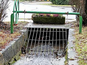 Bei starken Regenfällen schießt das Wasser des Feulner Baches über das Gitter hinweg auf die Dorfstraße.
