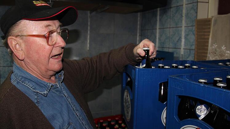 Dahinter stehen Bierkästen.