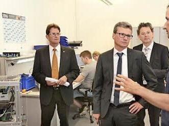 Beeindruckende Forschungsarbeiten. TTZ-Mitarbeiter Julian Endres (rechts) zeigt Staatssekretär Bernd Sibler einen Stromrichter im Beisein des stellvertretenden Landrats Peter Suckfüll (links) und TTZ-Leiter Professor Ansgar Ackva.  Foto: Stefan Kritzer