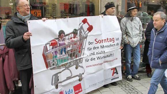 Dekan Hans Roppelt (links) mit Plakat: Der Sonntag ist für den Menschen da - und nicht für die Wirtschaft.