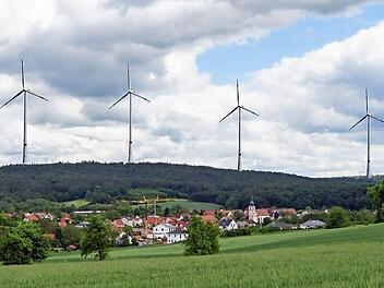 So wie auf dieser Fotomontage sollen die 230 Meter hohen Windräder nach Angaben der Initiative "Pro Natur Tonberg" einmal über Kirchlauter hinausragen.  Fotomontage: Steffen Schanz
