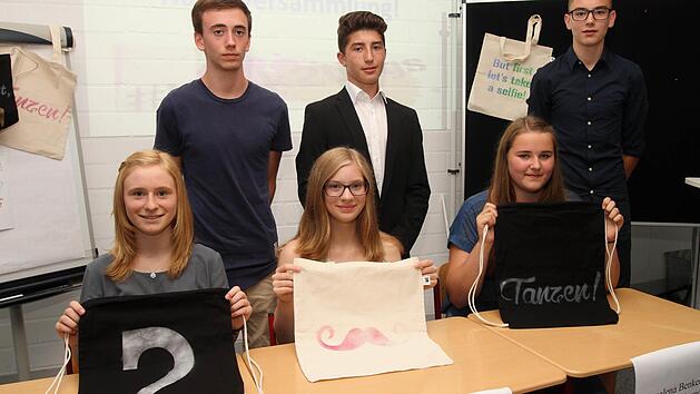 Das Vorstandsgremium der Schülerfirma "back2bags" mit einigen ihrer Produkte; (vordere Reihe von links) Laura Wiesneth (Verwaltung), Melissa Pfeufer (Finanzen) und Annalena Benkert (Vorstandsvorsitzende); (hintere Reihe von links) Cheyn Taylor (Produktion), Christian Knoblach (Marketing) und Jonas Kundmüller (Pressereferent).