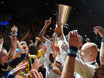 Berlins Trainer Sasa Obradovic (r) hält den Pokal hoch vor dem Berliner Fanblock. Foto: Jan-Philipp Strobel/dpa