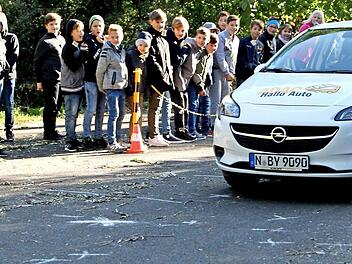 Ui, das Auto ist ganz schön schnell, und selbst nach dem Bremsen fährt es noch über die weißen Kreuze auf dem Boden: symbolisch für die Kinder. Mit 50 Stundenkilometern schlitterte der Wagen an den von den Kindern mit Kreide aufgezeigten Haltepunkten vorbei. Ein besonderer Lerneffekt war das für manches Kind, das den Anhalteweg eines Fahrzeuges jetzt genau sehen konnte. Foto: Günther Geiling
