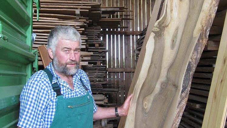 Hans Karl Hertel zeigt stolz besonders schöne Bretter seiner Holzsammlung