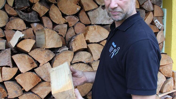 Bezirkskaminkehrermeister Markus Dütsch vor aufgeschlichtetem Brennholz in Steinberg Foto: Friedwald Schedel