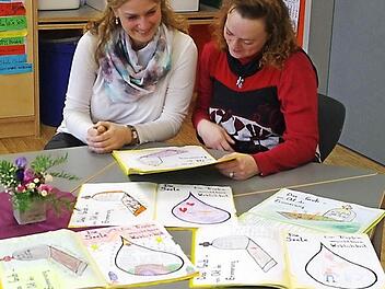 Wann, wie und warum ist man tot? Mit diesen schwierigen Fragen haben sich die Grundschüler künstlerisch auseinandergesetzt. Hospizkoordinatorin Annette Hümmer (links) und Lehrerin Yvonne Fritz-Schilling betrachten die Zeichnungen der Zweitklässler.  Foto: Heike Schülein