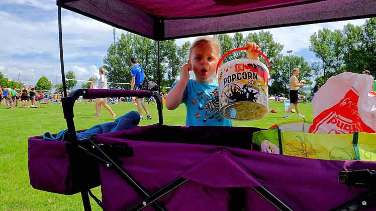 Die kleine Josephine aus Meiningen sucht mit ihrem Popcorn-Eimer den Schatten. Sie ist womöglich der Volleyball-Nachwuchs von übermorgen. Foto: Gerd Schaar