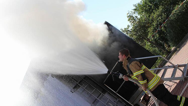 Draußen versuchte ein Feuerwehrmann, den Rauch mit Wasser zu binden, damit er nicht so weit ziehen kann.