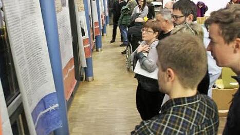Die Betroffenheit steht ihnen ins Gesicht geschrieben: Die Besucher der Ausstellung vor einigen der 24 Plakate in der Aula am Friedrich-Rückert-Gymnasium. Fotos: Ralf Kestel