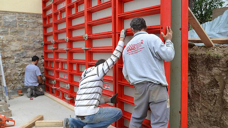 Mitarbeiter bringen eine Schalung an ein Wandelement an.