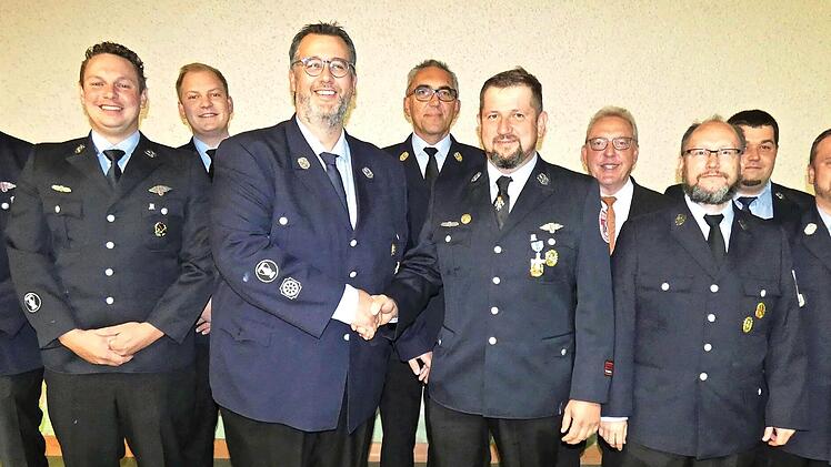 Nach 17 Jahren &uuml;bergab Bj&ouml;rn Sommerer (links im Vordergrund) sein Amt als Vereinsvorsitzender an Tobias Schirmer. Dahinter der neu gew&auml;hlte Vorstand mit B&uuml;rgermeister Harald H&uuml;bner und Kreisbrandinspektor Siegfried Zillig