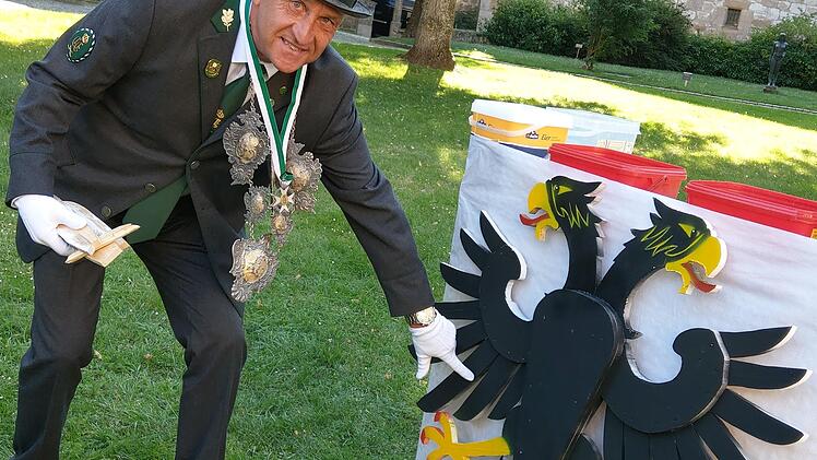Drei Federn aus der linken Schwinge hat Klaus Probst mit seinem Bolzen vom Rumpf des hölzernen Adlers geschossen. Er zeigt die Stelle an dem einen verbliebenen Adler der Schützengesellschaft Coburg. Foto: Simone Bastian