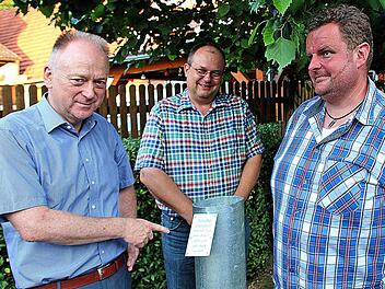 Dieser massive Metallzylinder symbolisiert das "Mürschter Finanzloch": Der Erste Bürgermeister Helmut Blank (links) und sein dritter Stellvertreter Axel Knauff (Mitte) begutachten das Werk. Geschaffen wurde es von Alfred Eckert, dem Vater von Stadtrat und Ortsreferent Jürgen Eckert (rechts). Foto: Dieter Britz