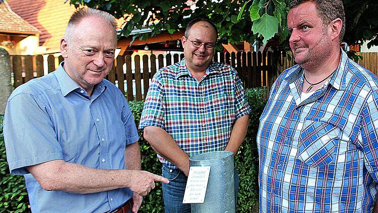 Dieser massive Metallzylinder symbolisiert das "Mürschter Finanzloch": Der Erste Bürgermeister Helmut Blank (links) und sein dritter Stellvertreter Axel Knauff (Mitte) begutachten das Werk. Geschaffen wurde es von Alfred Eckert, dem Vater von Stadtrat und Ortsreferent Jürgen Eckert (rechts). Foto: Dieter Britz