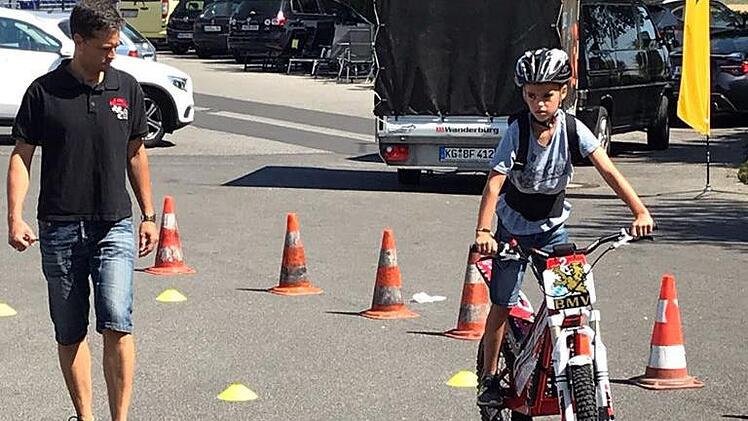 Erste "Gehversuche" auf einem elektrischen Motorrad unternahmen zahlreiche Mädchen und Jungen bei einem E-Trial-Schnupperkurs. Im Bild AMSC-Sportleiter Florian Arand, der einen Jungen beim Fahrversuch begleitet.Horst Pluntke