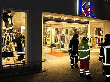 Aus der Zwischendecke des Bekleidungsgeschäftes drang Rauch in die Geschäftsräume. Die Feuerwehr öffnete die Decke (links). Foto: Ulrike Nauer