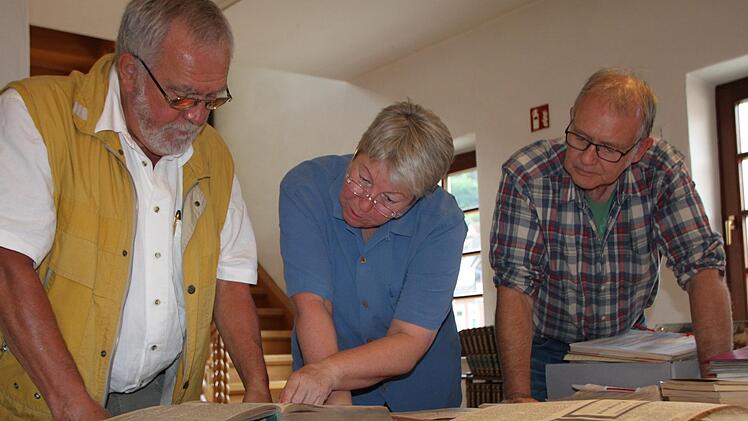 Dieter Rothkegel (von links), Gisela Salzmann und Matthias Dittmayer wälzen alte Zeitungsbände in der Stadtbibliothek. Annoncen ehemaliger Geschäfteinhaber der Ludwigstraße wecken ihr besonderes Interesse. Foto: Ulrike Müller
