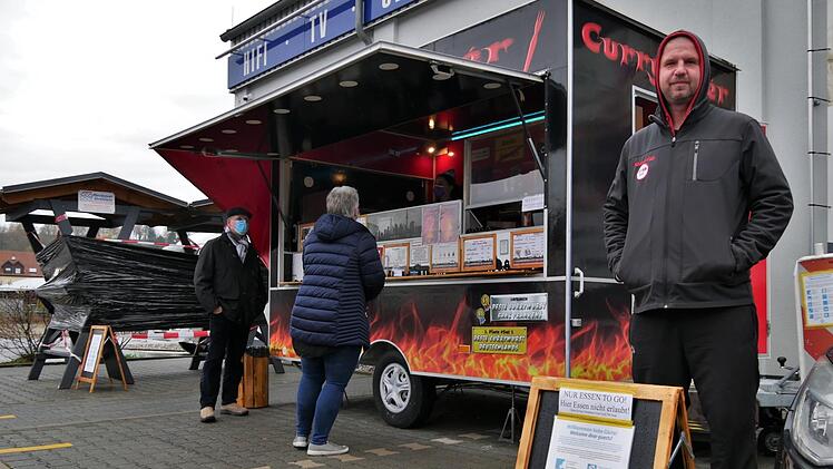 Der Weg zur Currywurst von Rainer Tröster (rechts) führt derzeit nur über Absperrbänder, Bodenmarkierungen und diverse Hinweisschilder. Foto: Sandra Hackenberg