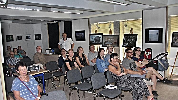 Blick auf einige der Besucher der Vernissage des Foto-Creativ Kreis Ebern, die dem Vortrag vom Vorsitzenden des Klubs, Steffen Schanz (hinten rechts) beiwohnen. Foto: Helmut Will