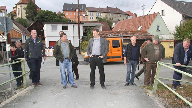 Die Stadträte begutachten den Zustand der kleinen Brücke über die Steinach. Das Geländer ist windschief.
