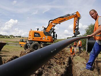 Mitarbeiter einer Baufirma verlegen im Gemeindegebiet Ebensfeld (Lkrs. Lichtenfels) fünf Zentimeter dicke Leerrohre. Die Glasfaserkabel werden später mit einer Maschine eingeblasen. Foto: Matthias Hoch