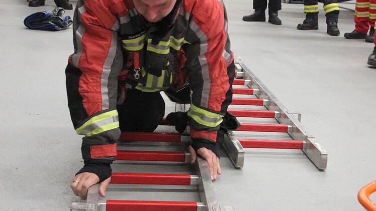 Wie man sich mit flach liegenden Leitern über eine Eisfläche bewegt, übten die Feuerwehrleute in der Fahrzeughalle. Foto: Matthias Einwag