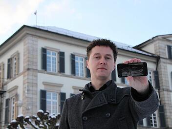 Alles im Blick: Dirk Döppert zeigt auf seinem Smartphone den Livestream. Die dazu gehörige Webcam ist auf dem Dach des Elisabethenhofes inmitten des Schlossparks des Staatsbads Bad Brückenau angebracht (links oben im Bild). Foto: Ulrike Müller
