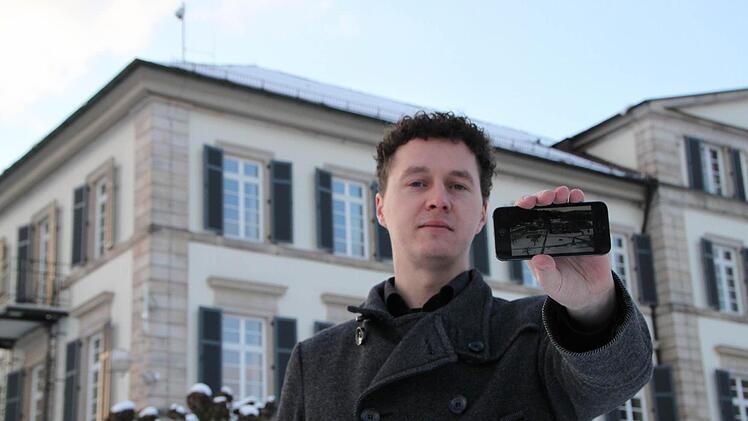 Alles im Blick: Dirk Döppert zeigt auf seinem Smartphone den Livestream. Die dazu gehörige Webcam ist auf dem Dach des Elisabethenhofes inmitten des Schlossparks des Staatsbads Bad Brückenau angebracht (links oben im Bild). Foto: Ulrike Müller