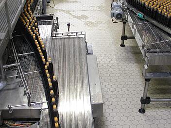 Eine der Produktionslinien in der Abfüllerei in Knetzgau. Hier laufen frisch befüllte Mehrwegflaschen über das Band, einen Produktionsschritt vorher ging es durch die Waschmaschine. Fotos: Andreas Lösch