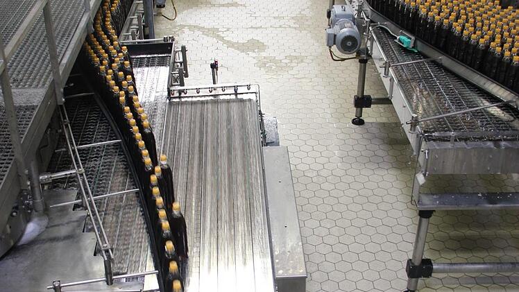 Eine der Produktionslinien in der Abfüllerei in Knetzgau. Hier laufen frisch befüllte Mehrwegflaschen über das Band, einen Produktionsschritt vorher ging es durch die Waschmaschine. Fotos: Andreas Lösch