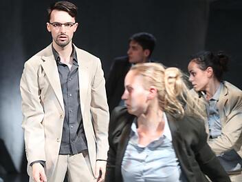 Winston (Federico Frigo) bleibt mit eigenständigem Denken hängen im Überwachungsstaat. Julia (Mireia Martinez Pineda, ganz rechts) nähert sich ihm verstohlen.  Foto: Henning Rosenbusch