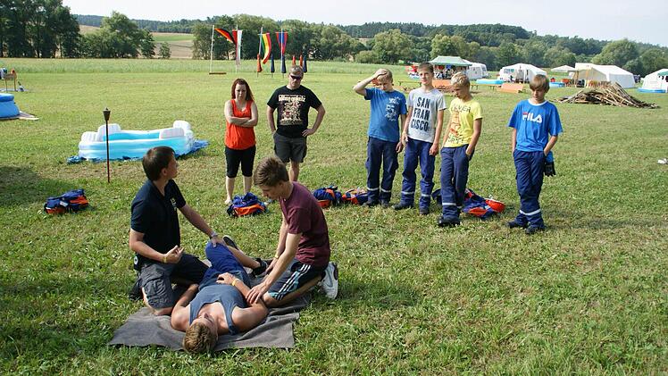 Wie war das nochmal mit der stabilen Seitenlage? Luis spielt das Opfer, Daniel übt - und auch die Betreuer Sabine und Sven Ankenbrand (links) nehmen die Auffrischung gerne mit.